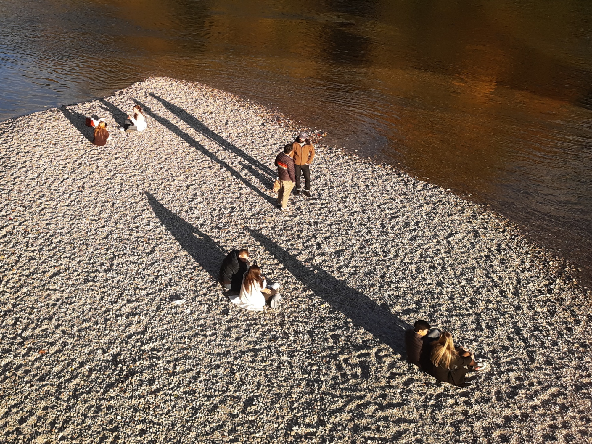 couples sitting on a bank in a river